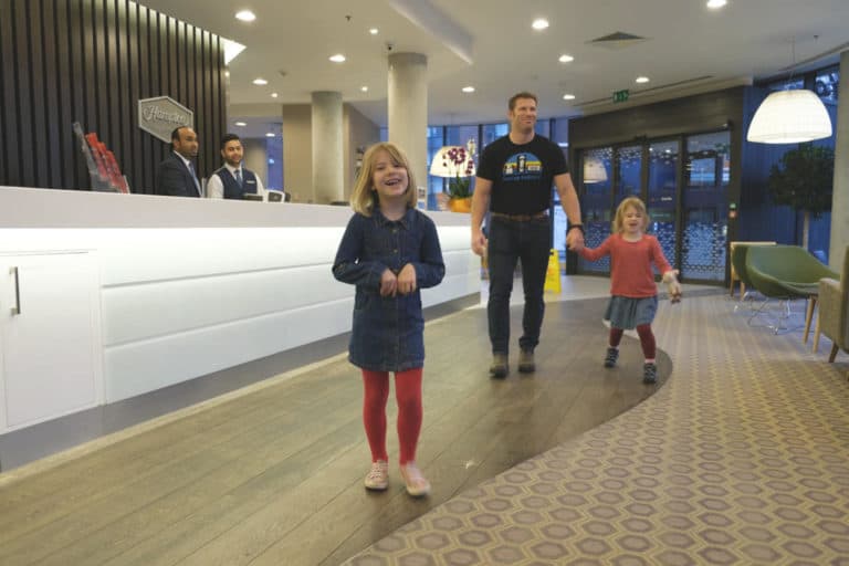 Family walking through reception of Hampton by Hilton Waterloo in London