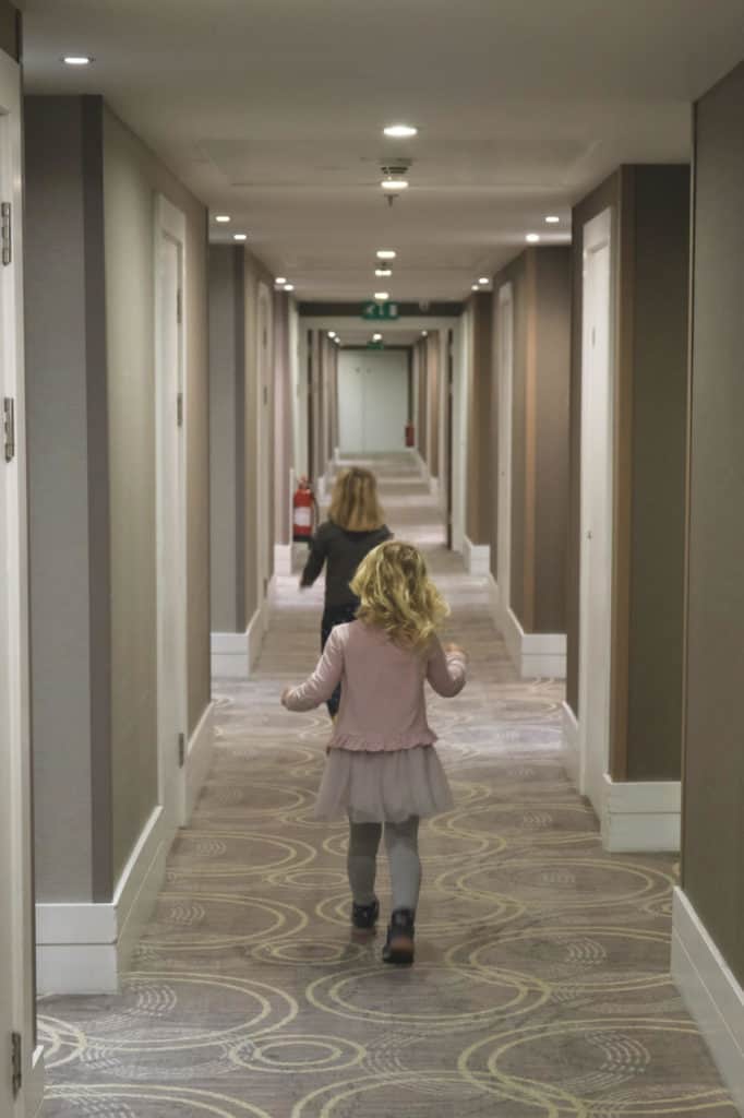 Children running down a hotel corridor