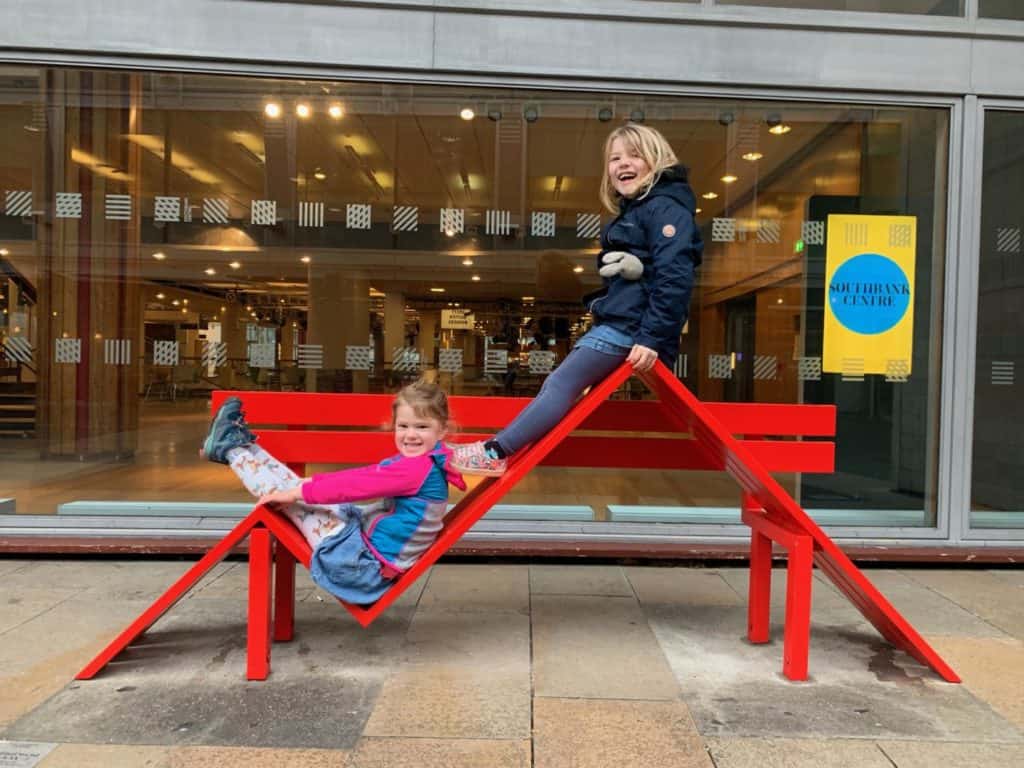 Kids sat on bench sculpture outside Southbank Centre in London