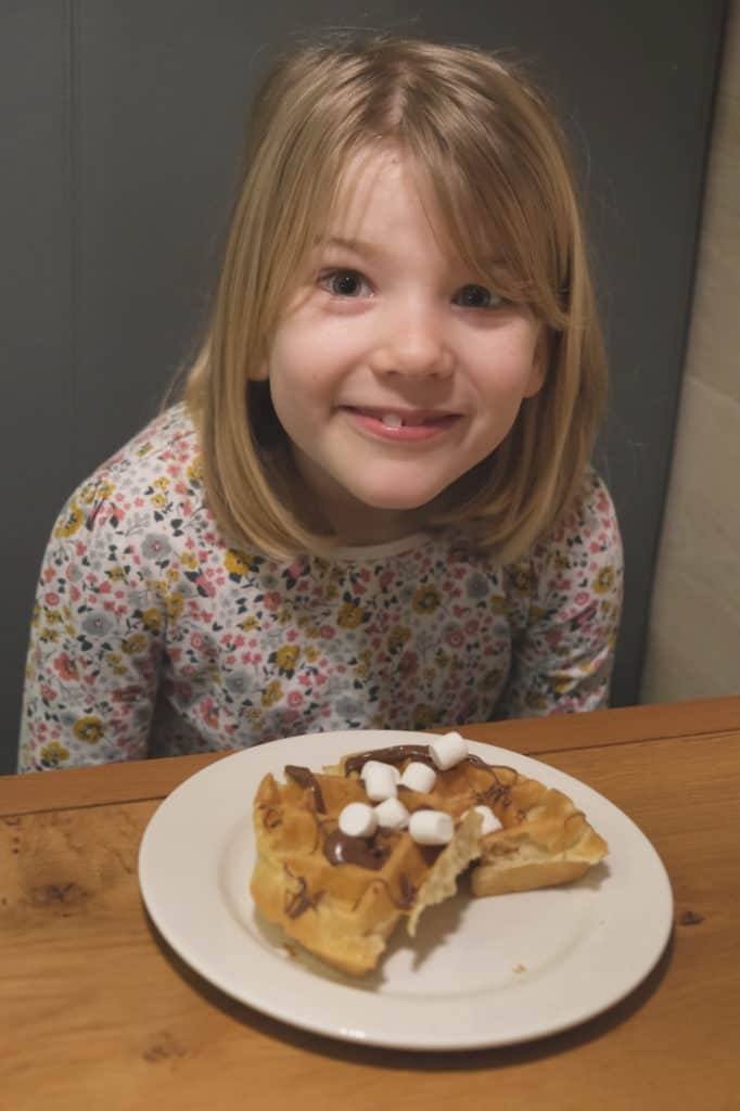 Tot looking happy with her breakfast waffle