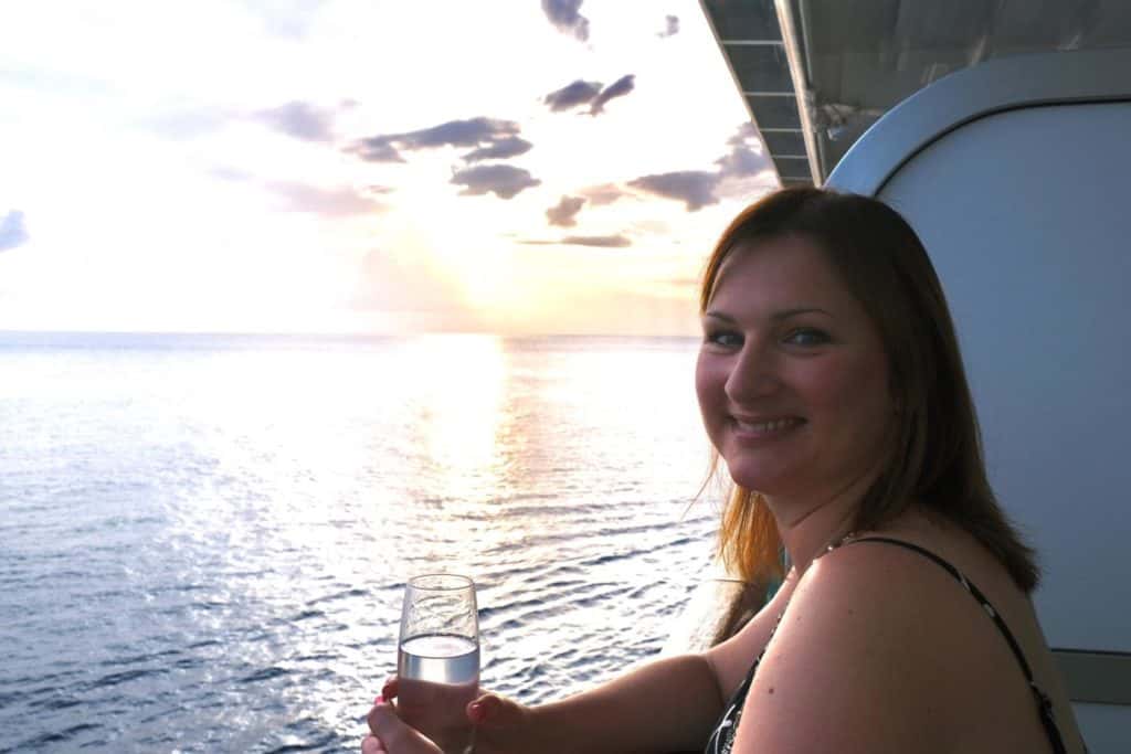 Claire having a glass on wine on cruise ship balcony at sunset - are is the P&O drinks package worth it?
