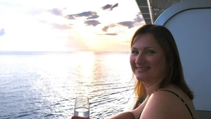 Claire having a glass on wine on cruise ship balcony at sunset - are is the P&O drinks package worth it?