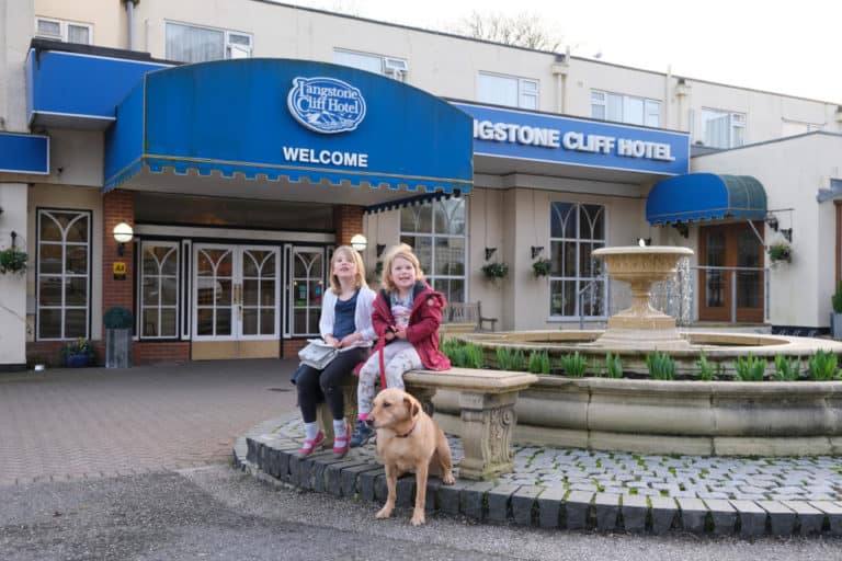 Tin Box girls and Dog outside the entrance to Langstone Cliff Hotel in South Devon