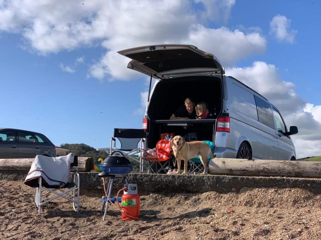 VW T5 parked at a beach with barbecue and chairs set out