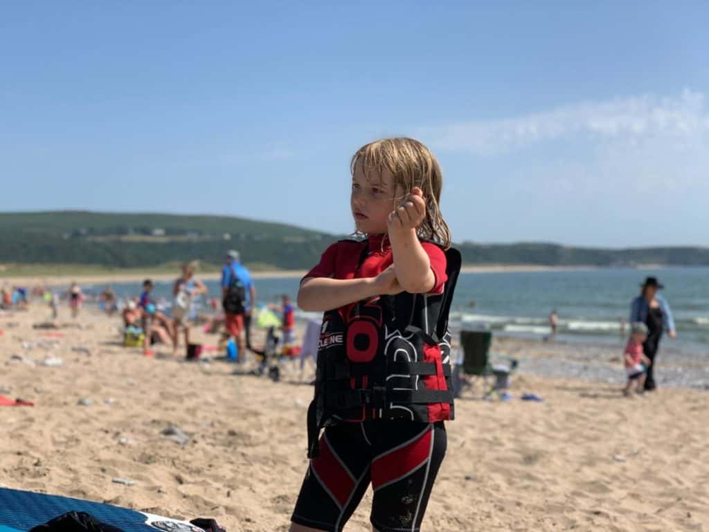 Tot wearing Circle One buoyancy aid on beach in Wales