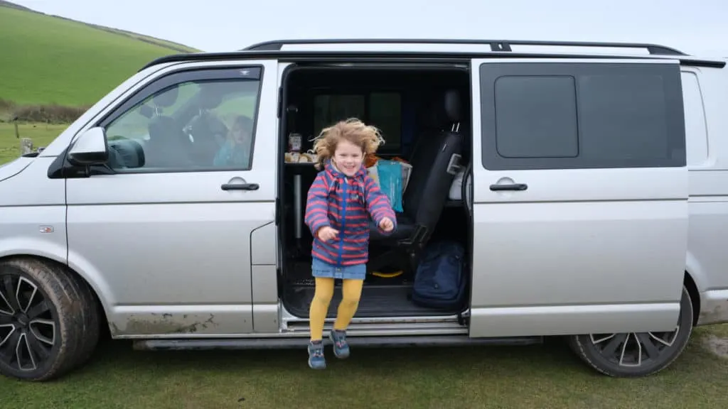 Girl jumping out of the side of a stationary VW T5 van