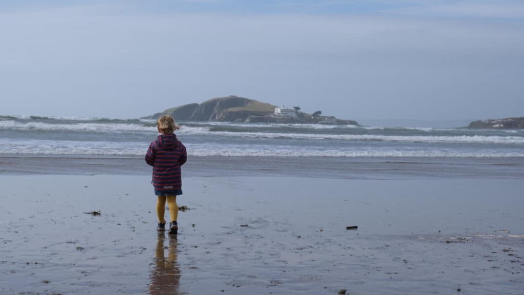 Kid on Bantham Beach in Devon looking towards Burgh Island