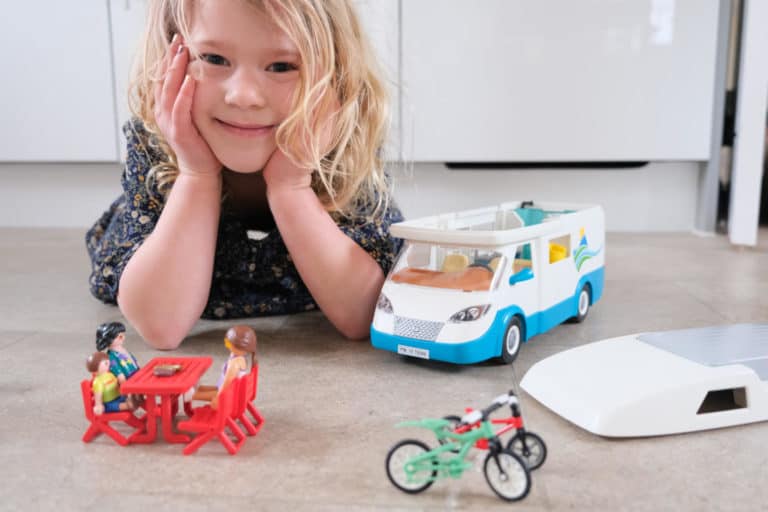 Girl with PLAYMOBIL Family Camper camping play set