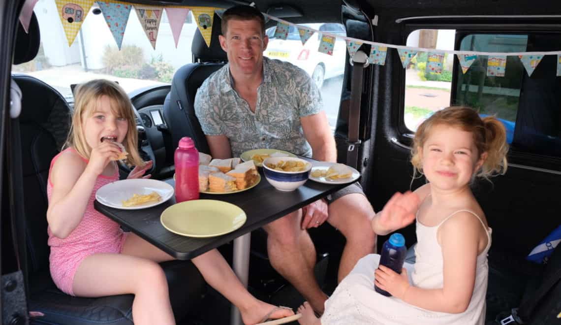 Family eating lunch in camper van for Big Little Tent Festival