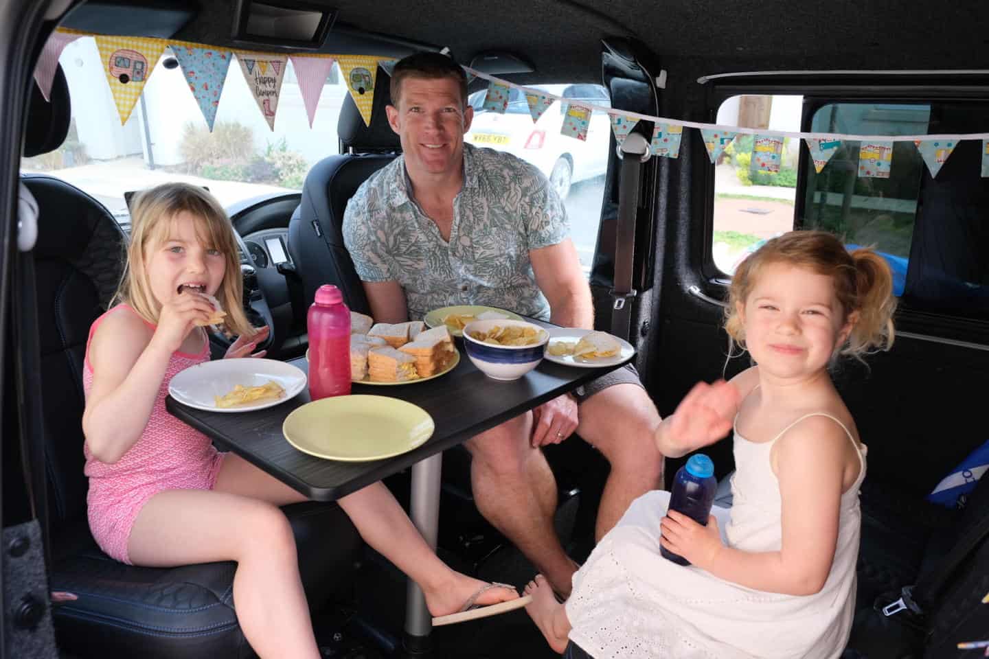 Family eating lunch in camper van for Big Little Tent Festival