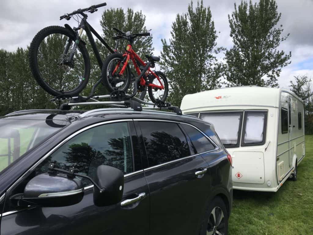 Bikes on top of car with caravan in tow