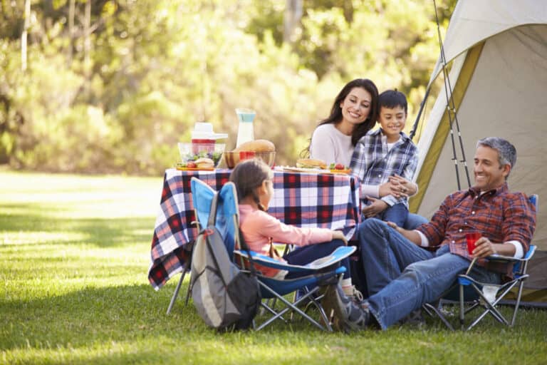 Family sitting outside a tent in a field