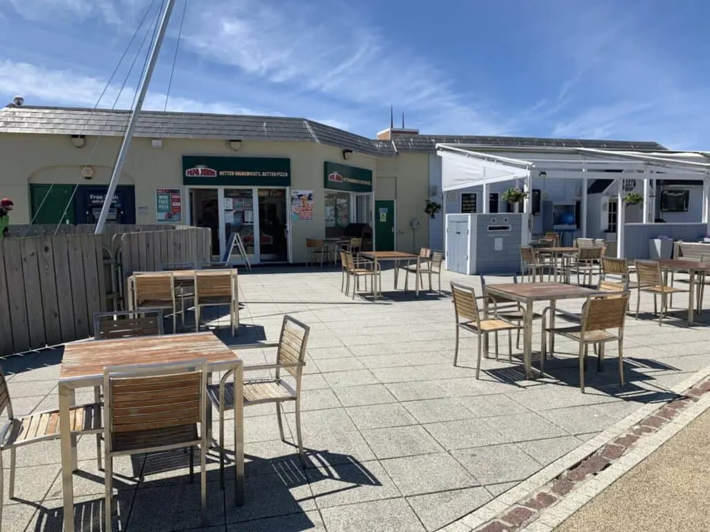 Tables and chairs outside Papa John's pizza takeaway