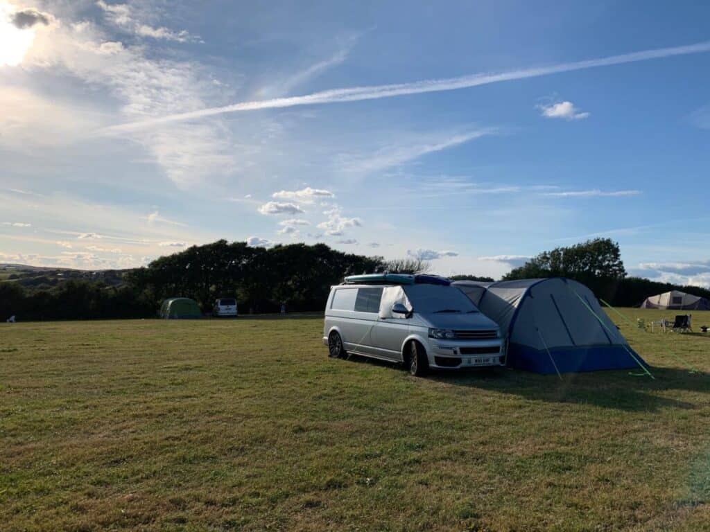 Camper van pitched in camping field at Wilton Farm in South Hams, Devon 
