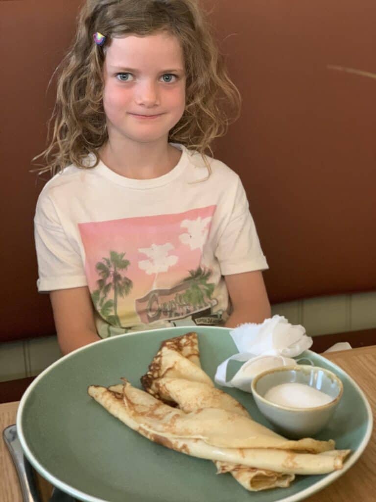 Child with plate of pancakes