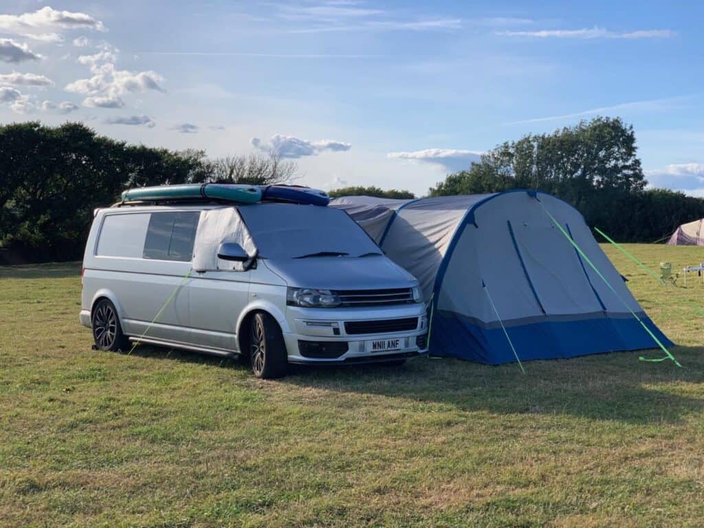 VW T5 camper van with awning in camping field