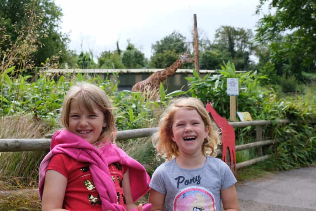 Girls and giraffe at Paignton Zoo in Devon