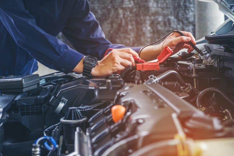 Hands of car mechanic working in auto repair service.