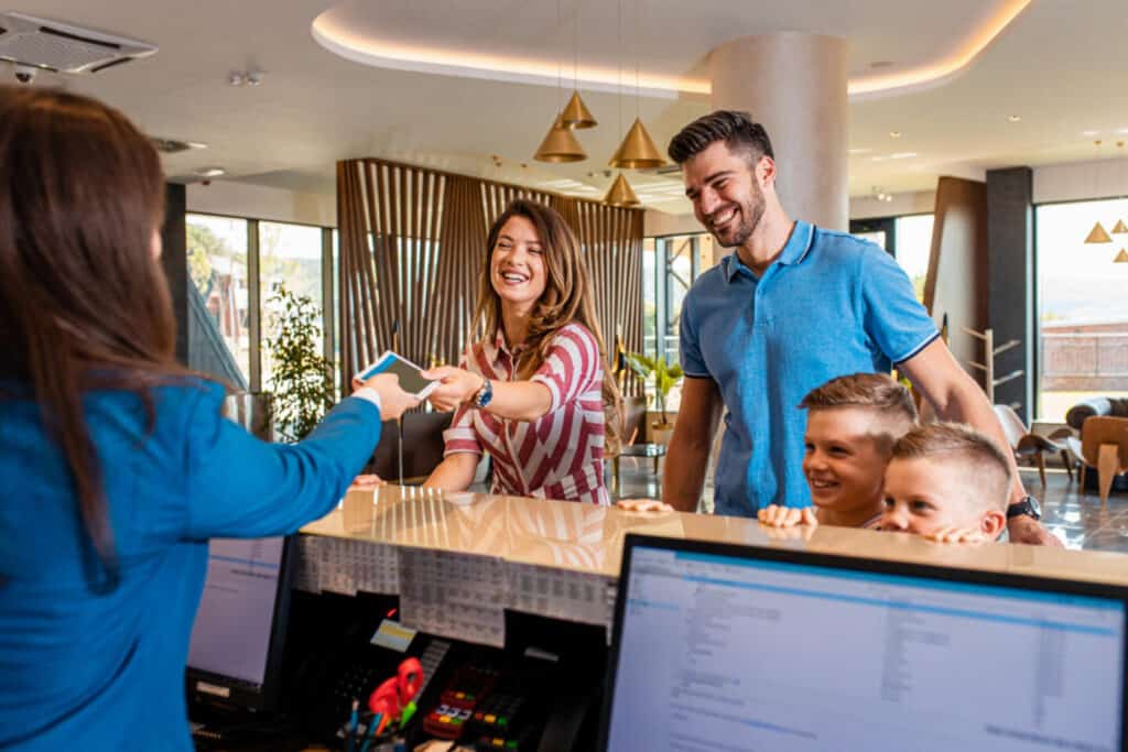 Happy family arriving at hotel reception