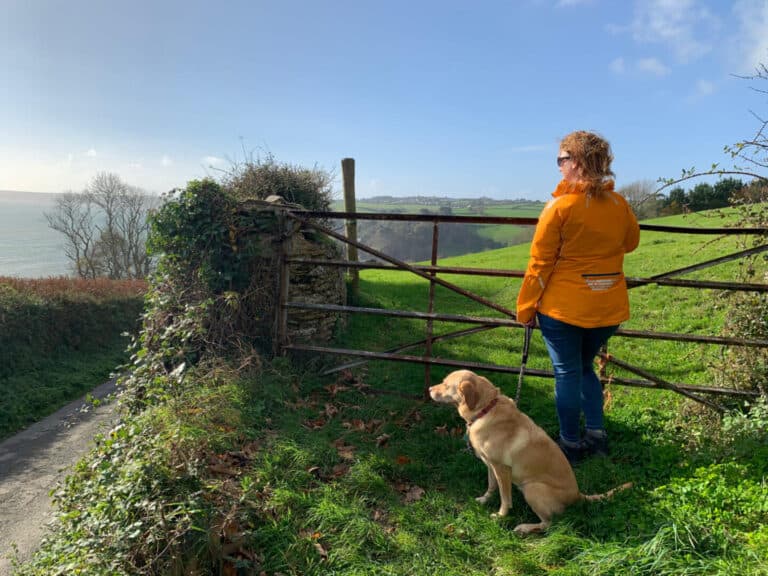 Claire and dog standing at gate on country lane