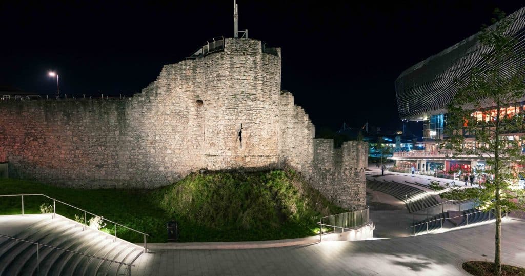 Illuminated medieval Southampton walls against the modern city architecture
