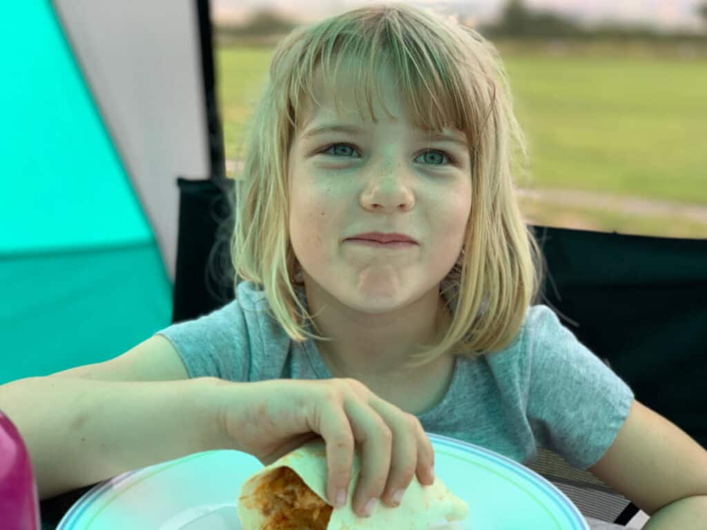 Child eating fajitas while camping