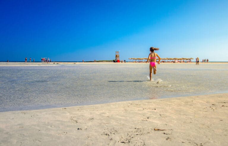 Girl running across sand at Elafonissi Beach in Crete