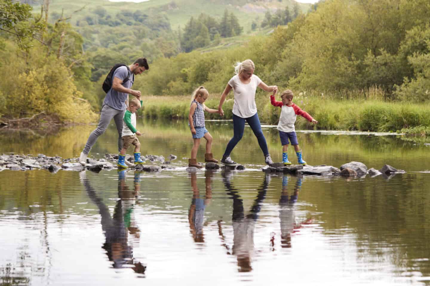 Family crossing river in Lake District