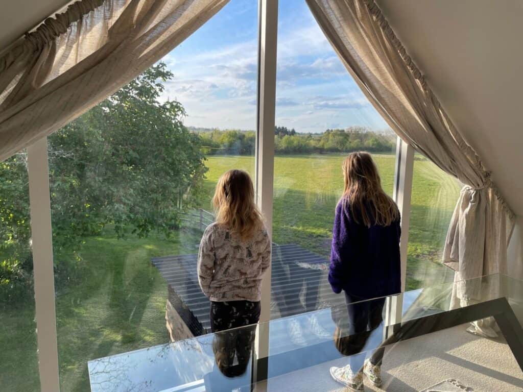 Girls looking out of glass wall in master bedroom