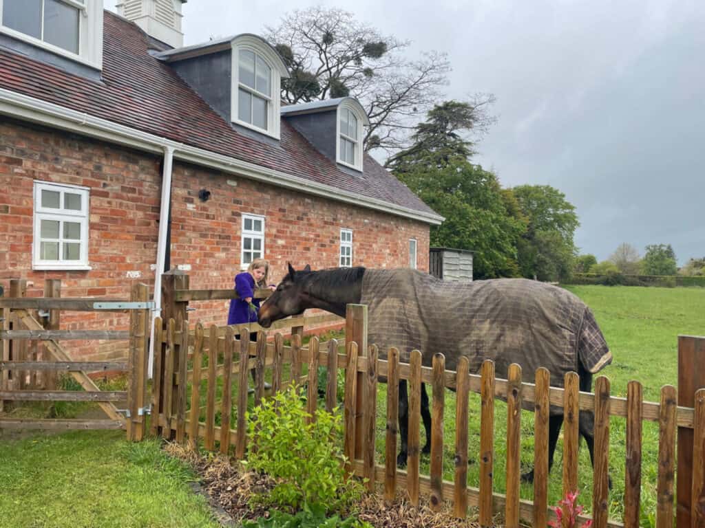 Enfant réunion cheval à l'extérieur cottage de luxe dans les Cotswolds
