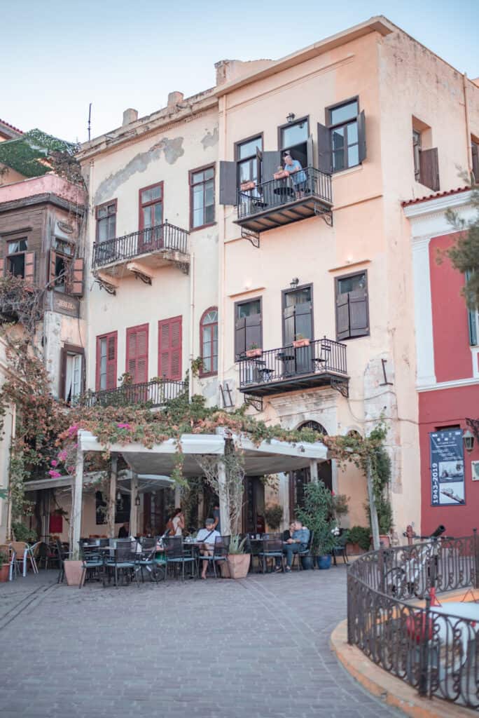 Exterior of Alcanea Hotel in Crete with restaurant tables set out in the street