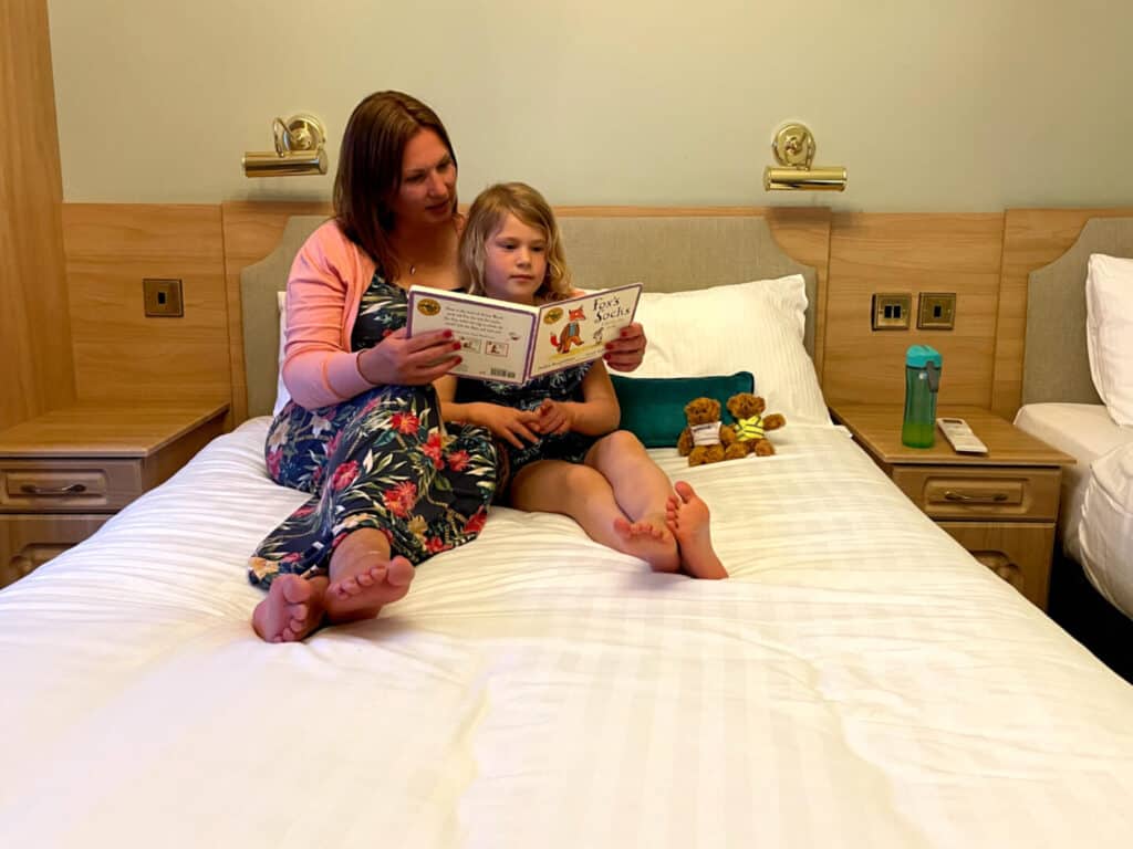 Mum and daughter sat on hotel bed