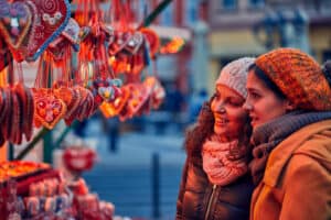 Friends looking at decorated biscuits at a Christmas market