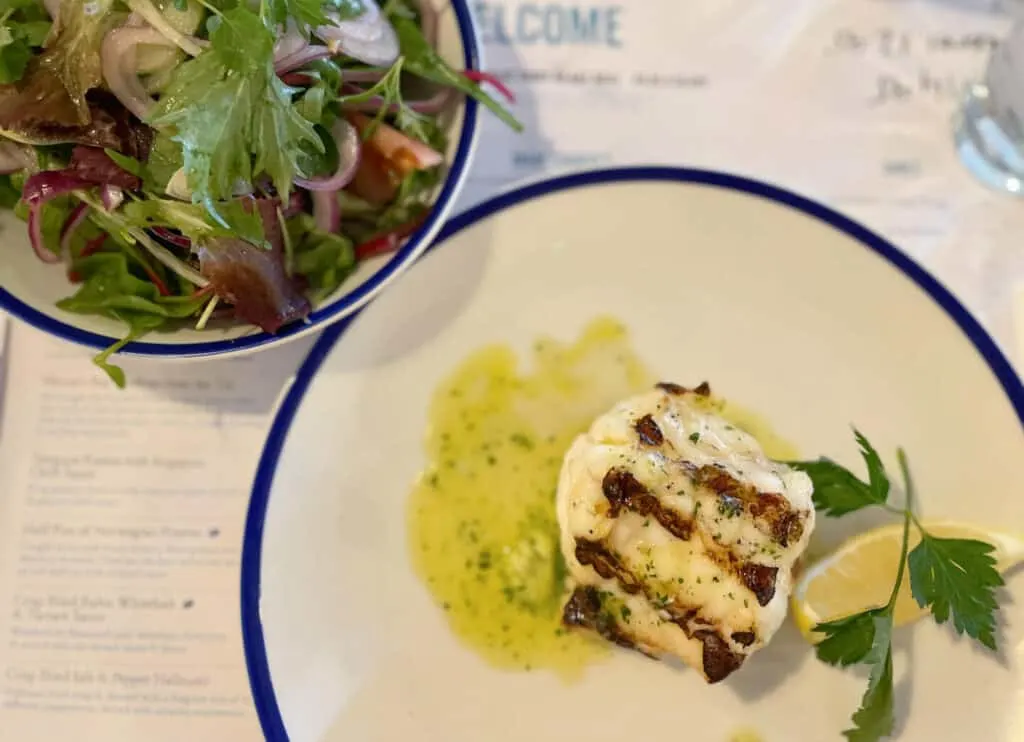 Monk fish steak in butter and garlic sauce with side salad