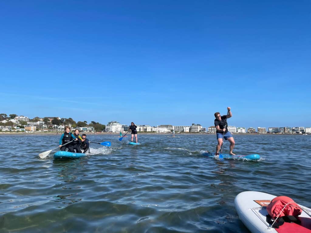 Family having a race on stand up paddle boards