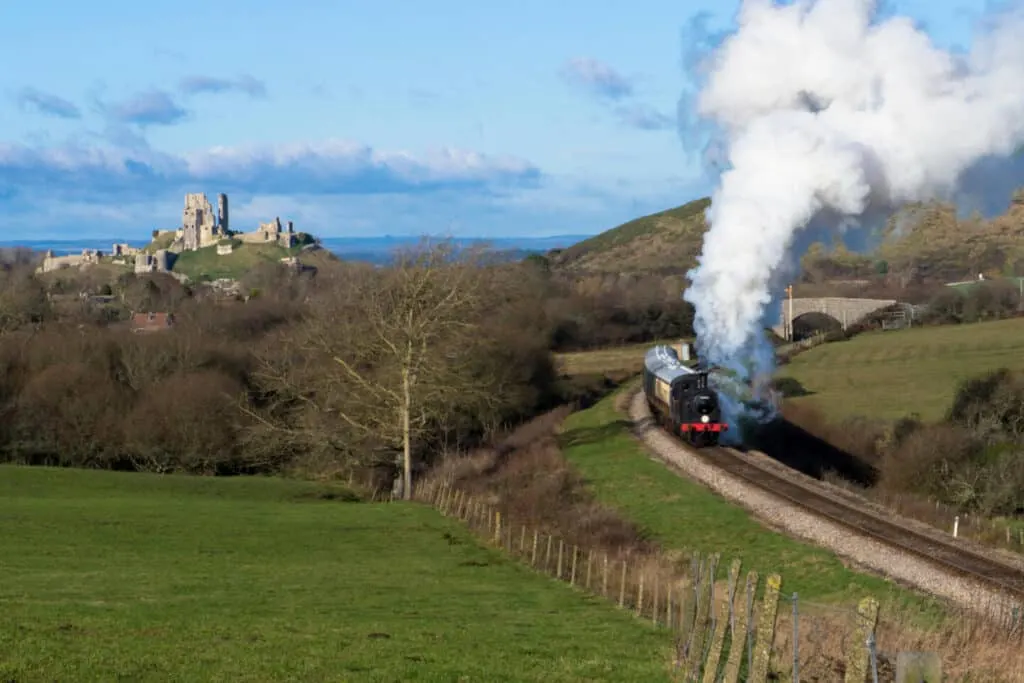 Steam train travels on Swanage Railway from Corfe Castle to Swanage