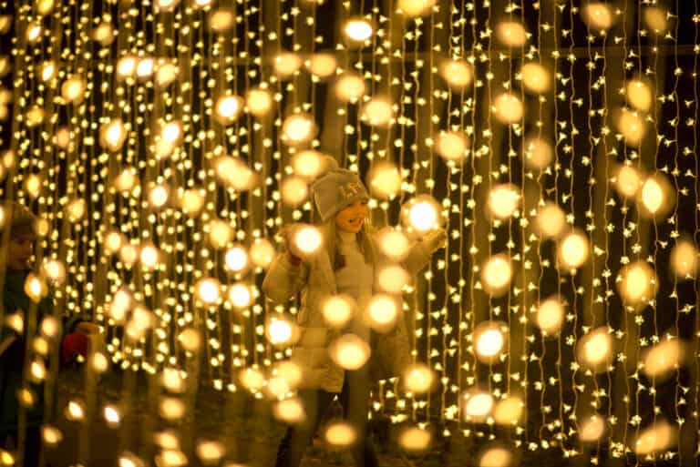 Child running through Christmas light trails at Kew