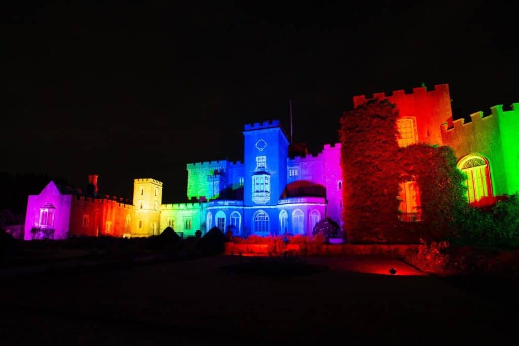 Powderham Castle illuminated in rainbow coloured light