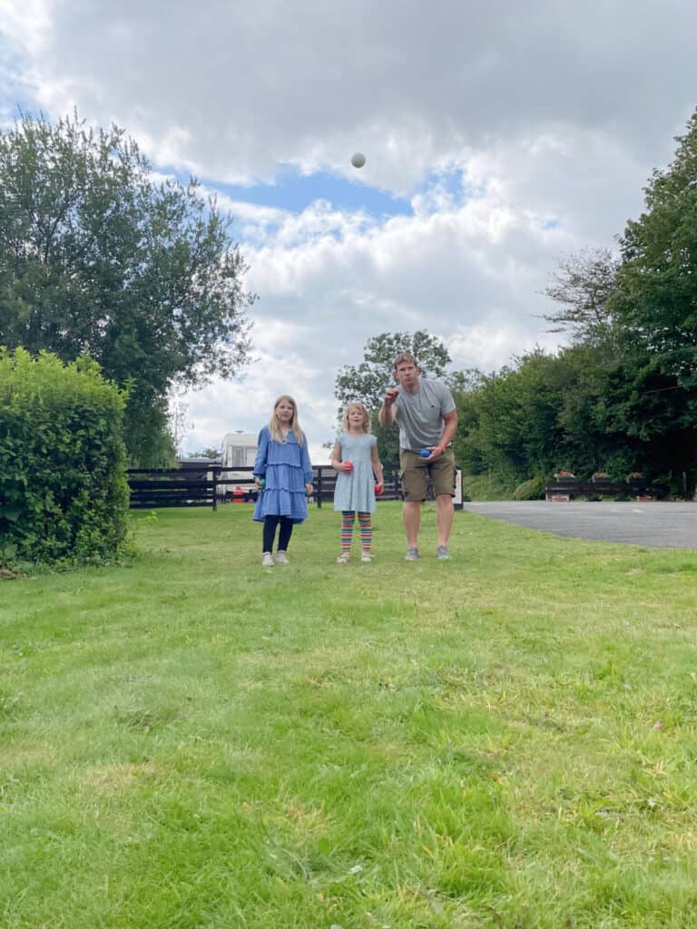 Family playing boules son campsite