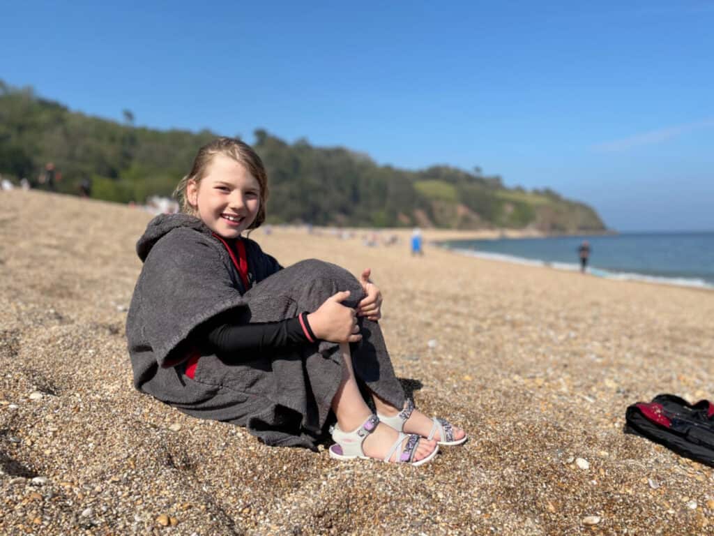 Tot sat in towel on beach at Blackpool Sands
