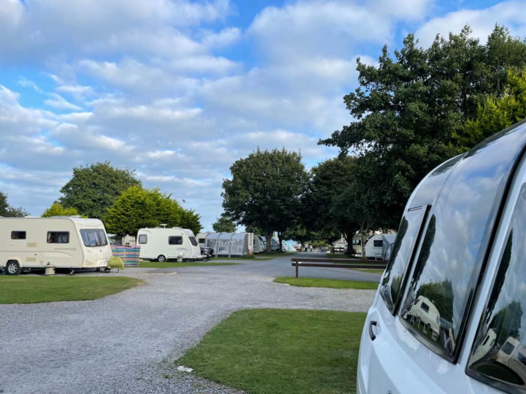 View of campsite with caravans parked on gravel pitches