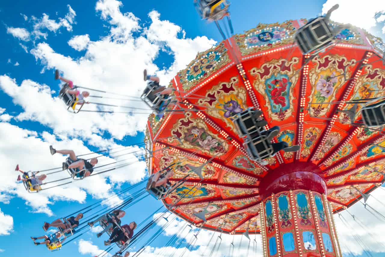 Carousel in motion in amusement park on blue sky background
