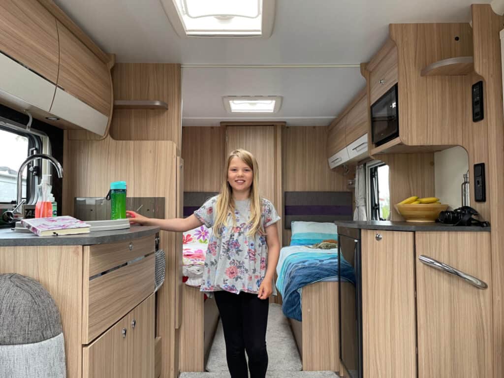 Girl stood in the kitchen area of caravan