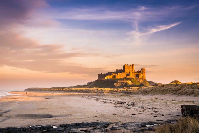 Bamburgh Castle on the Northumberland coastline, bathed in late afternoon golden sunlight