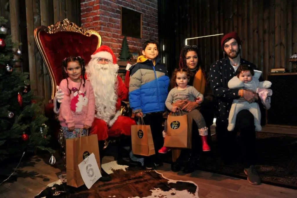 Family picture of 2 adults and 4 children with Father Christmas