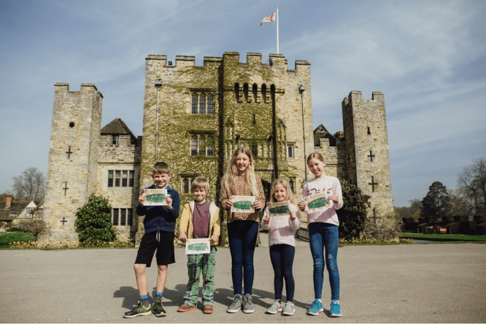 Five children stand in front of Hever castle holding trail sheets