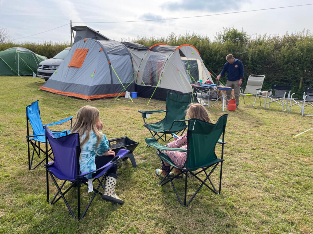 Children sat in camping chairs in front of the Wichenford Breeze inflatable tent