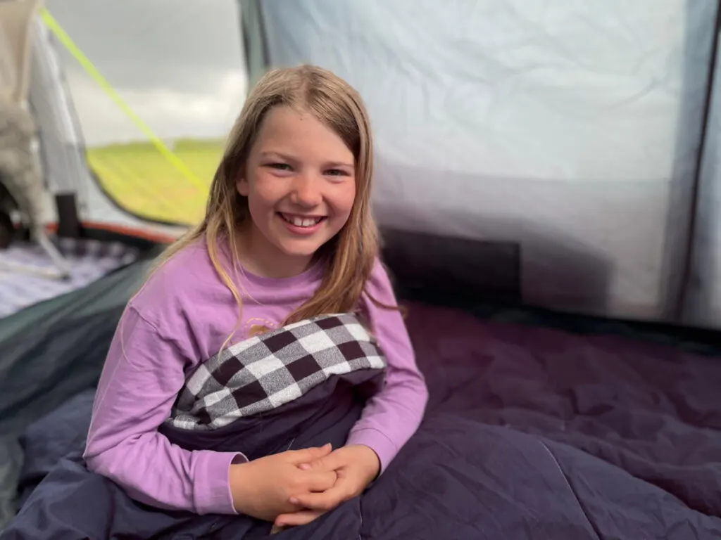 Child in sleeping bag in tent
