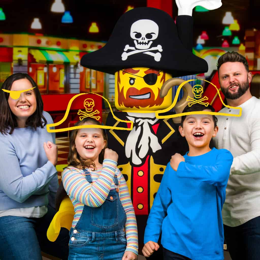 A family posing with a large Pirate LEGO figure