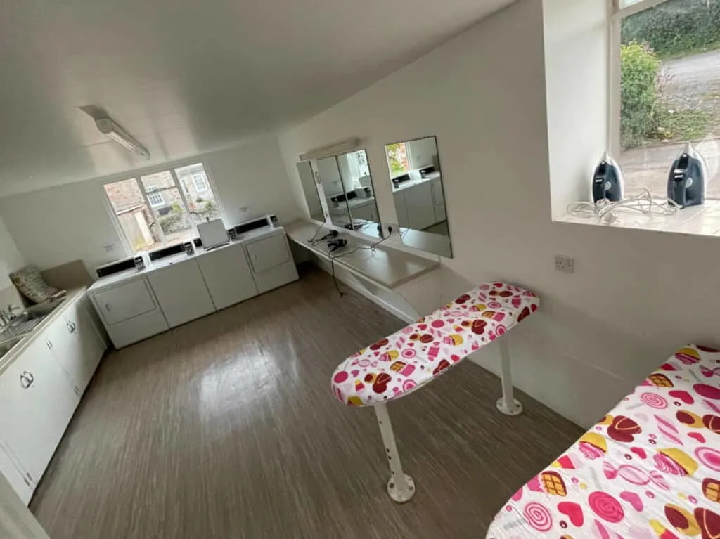 Ironing boards ad washing machines in campsite laundry room
